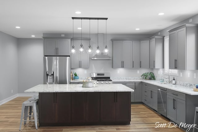 kitchen with appliances with stainless steel finishes, hardwood / wood-style flooring, and a center island