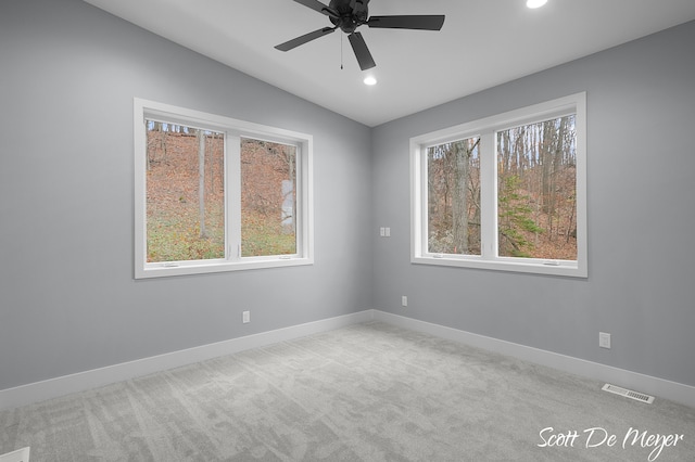 carpeted empty room with vaulted ceiling and ceiling fan