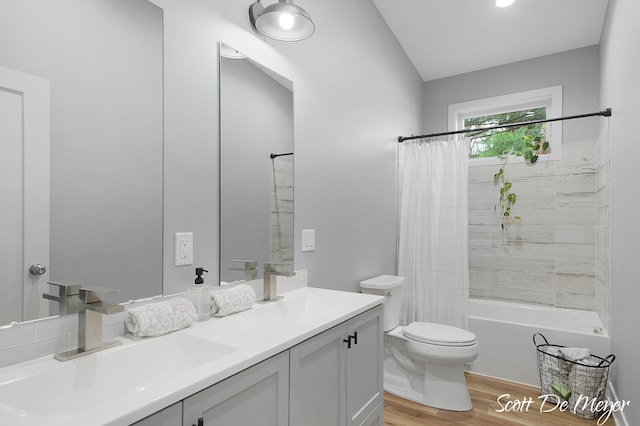 full bathroom featuring vanity, toilet, hardwood / wood-style floors, shower / tub combo with curtain, and lofted ceiling