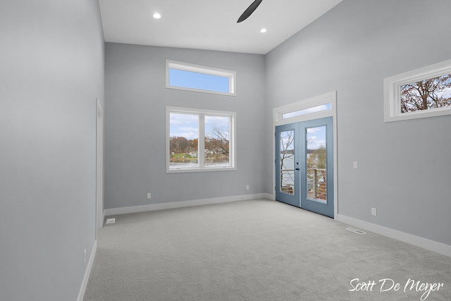 unfurnished room with high vaulted ceiling, french doors, light carpet, and ceiling fan