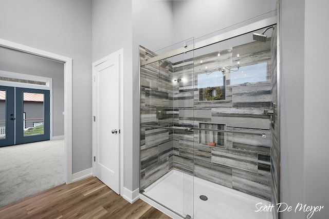 bathroom with wood-type flooring, an enclosed shower, and french doors