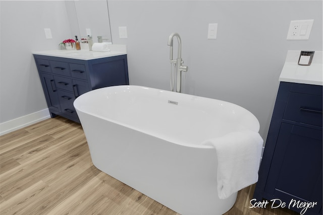 bathroom with a bathtub, vanity, and hardwood / wood-style flooring