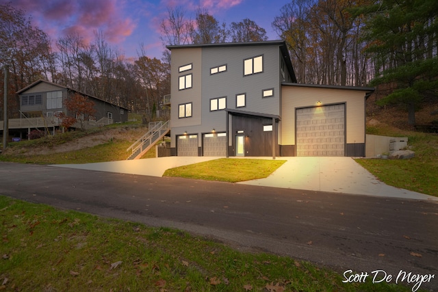 contemporary home featuring a garage and a yard