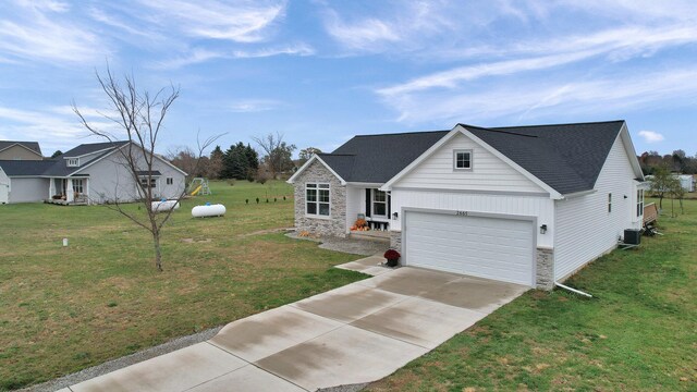 view of front of home with a garage, central AC, and a front yard