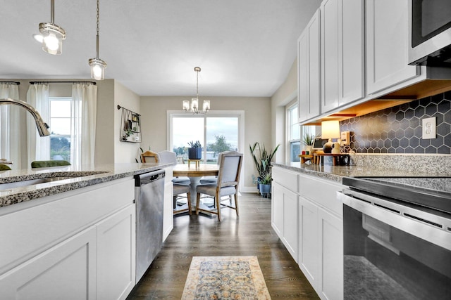 kitchen featuring pendant lighting, a wealth of natural light, and stainless steel appliances