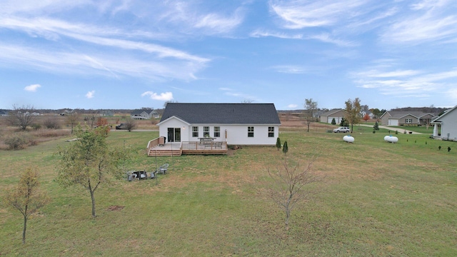 back of house featuring a lawn and a wooden deck