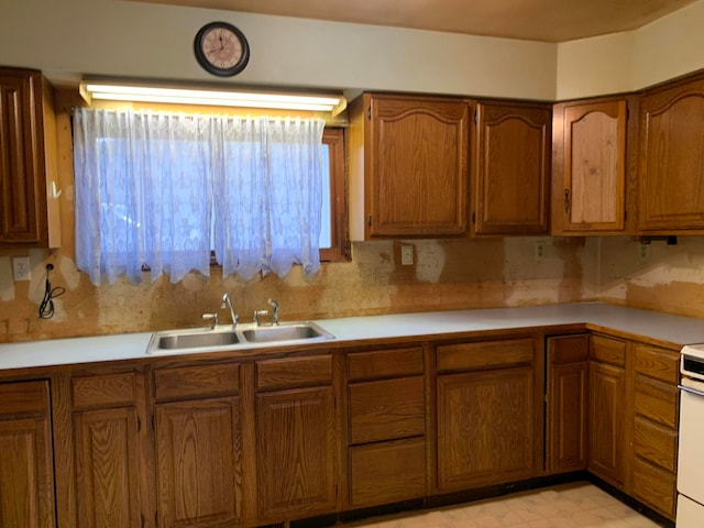 kitchen with sink, white stove, and backsplash