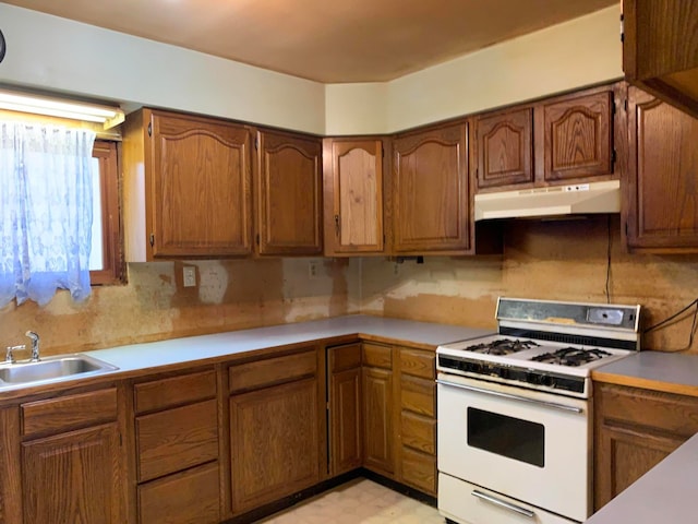 kitchen featuring white stove and sink