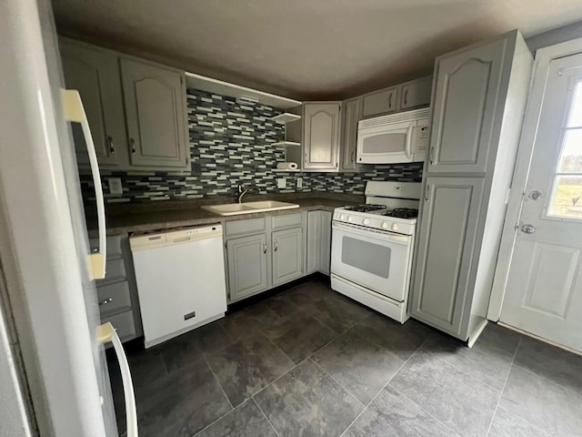 kitchen featuring sink, gray cabinetry, white appliances, and tasteful backsplash