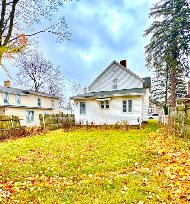 rear view of property featuring a yard