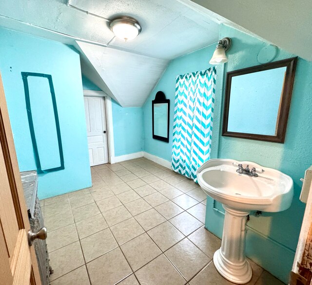 bathroom featuring vaulted ceiling and tile patterned flooring