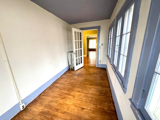 corridor with french doors and dark hardwood / wood-style floors