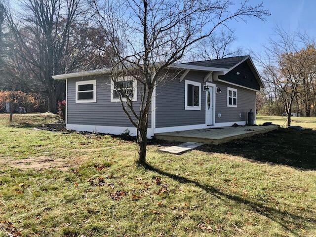 back of house with a patio area and a lawn