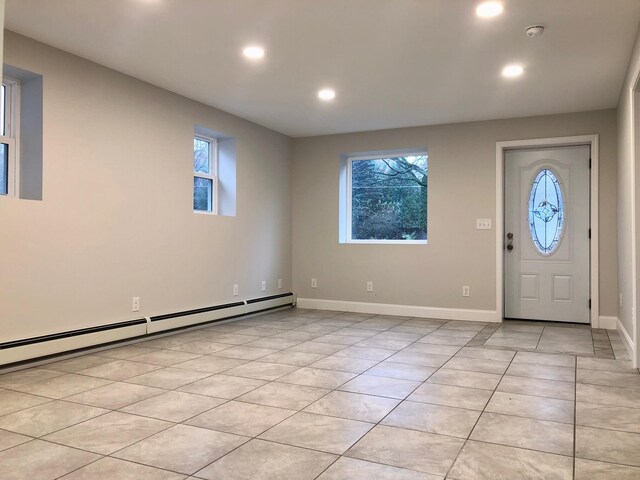 entrance foyer featuring a baseboard heating unit and light tile patterned floors