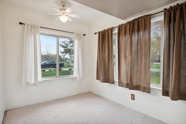 carpeted empty room featuring a wealth of natural light and ceiling fan