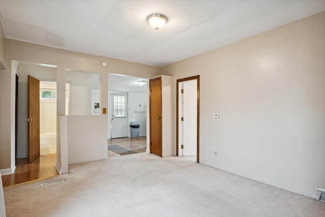 unfurnished room featuring light carpet