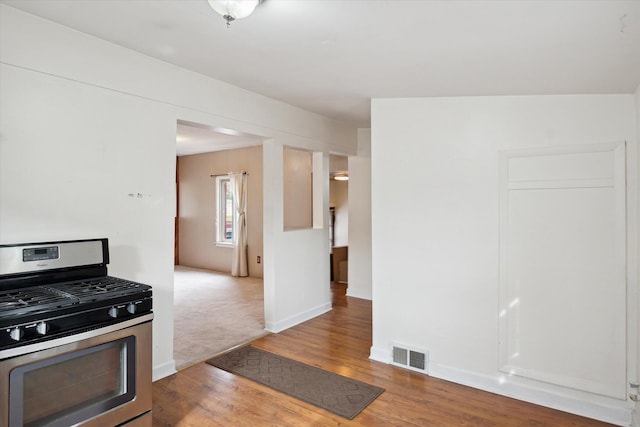 kitchen featuring gas stove and wood-type flooring