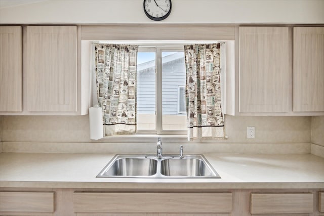 kitchen with light brown cabinetry and sink