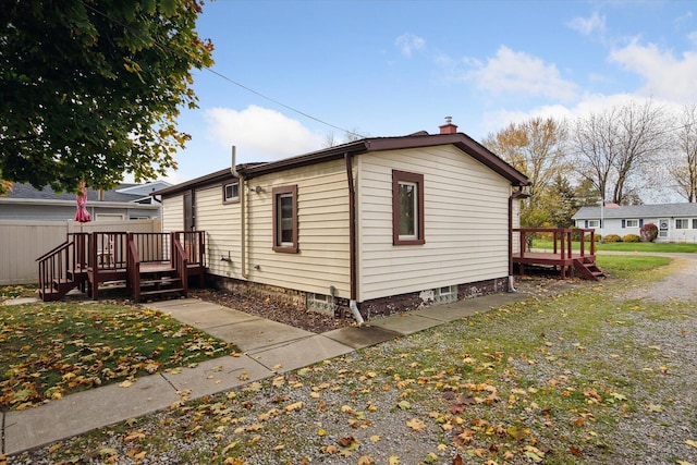 view of side of home featuring a deck and a yard