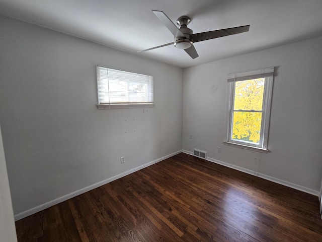 unfurnished room with ceiling fan, dark wood-type flooring, and a wealth of natural light