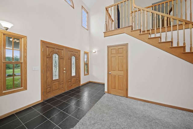 tiled entrance foyer with a towering ceiling