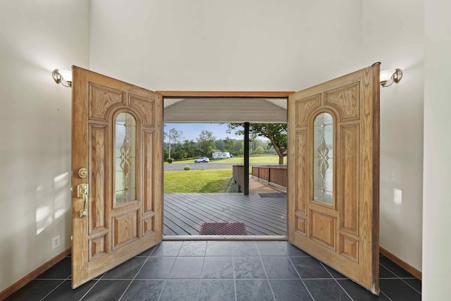 foyer featuring dark tile patterned floors