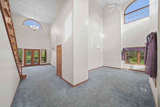 entrance foyer featuring a towering ceiling, french doors, and carpet