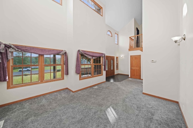 interior space with high vaulted ceiling and carpet