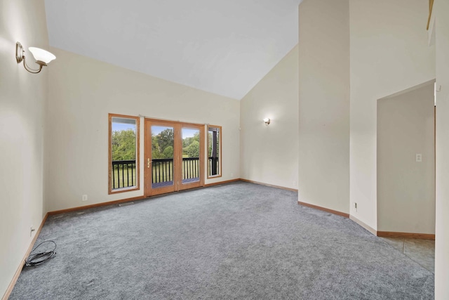 spare room with high vaulted ceiling and carpet floors