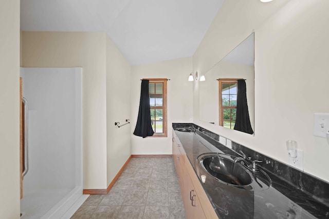 bathroom featuring vanity, vaulted ceiling, and tile patterned flooring