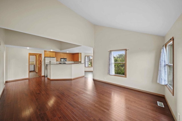 unfurnished living room featuring hardwood / wood-style floors and high vaulted ceiling