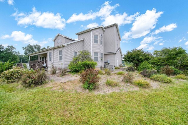 view of property exterior with a yard and a wooden deck