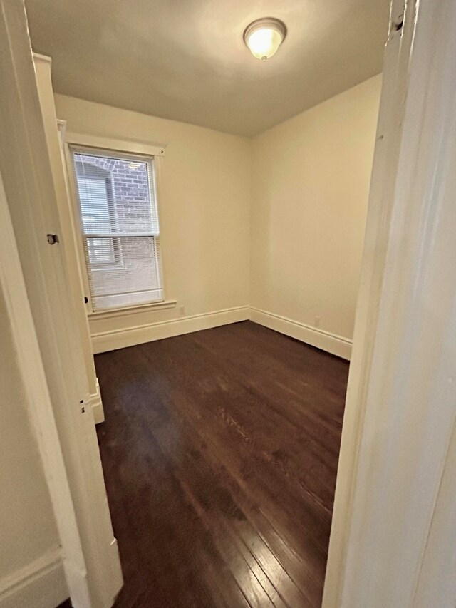 unfurnished room with dark hardwood / wood-style floors