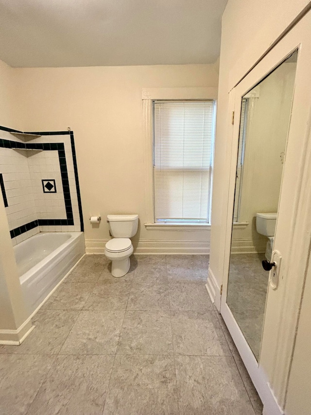 bathroom with toilet, tile patterned flooring, and a bathing tub