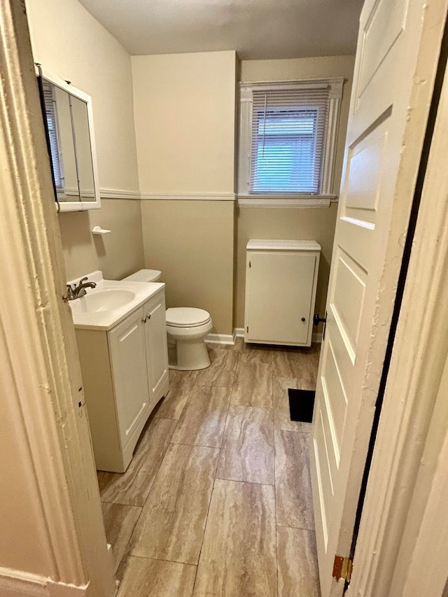 bathroom featuring radiator heating unit, vanity, and toilet