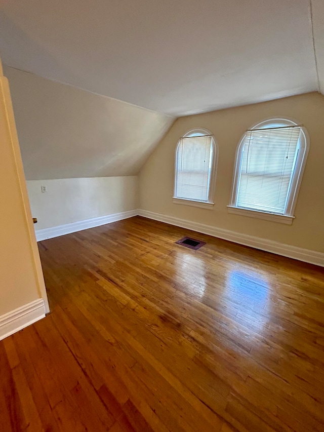 bonus room featuring lofted ceiling and dark hardwood / wood-style flooring