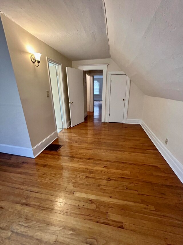 bonus room featuring lofted ceiling and hardwood / wood-style flooring