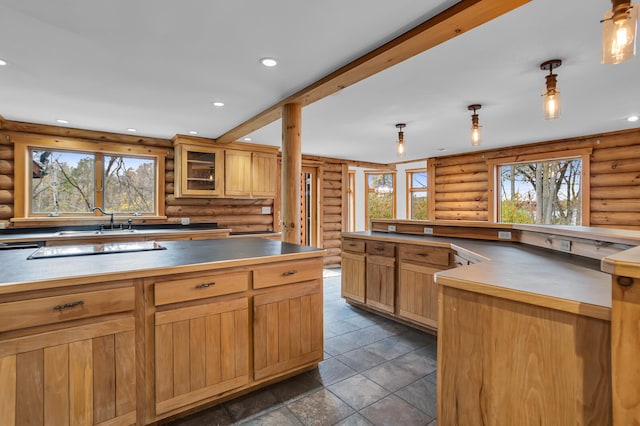 kitchen featuring rustic walls, sink, and decorative light fixtures