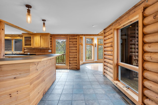 kitchen featuring hanging light fixtures and rustic walls