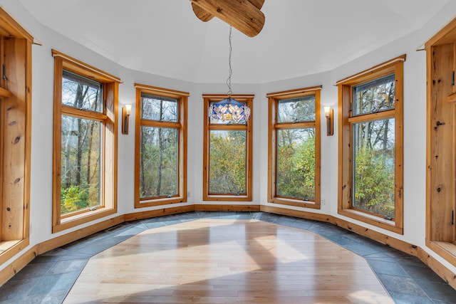 unfurnished sunroom featuring a wealth of natural light and a chandelier