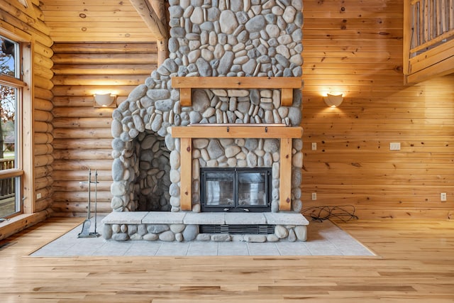 interior space with log walls, wood-type flooring, and a fireplace