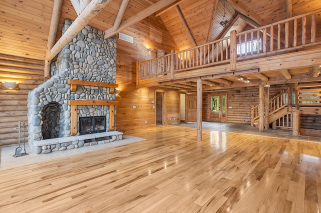 unfurnished living room with hardwood / wood-style flooring, wooden ceiling, high vaulted ceiling, beam ceiling, and a fireplace