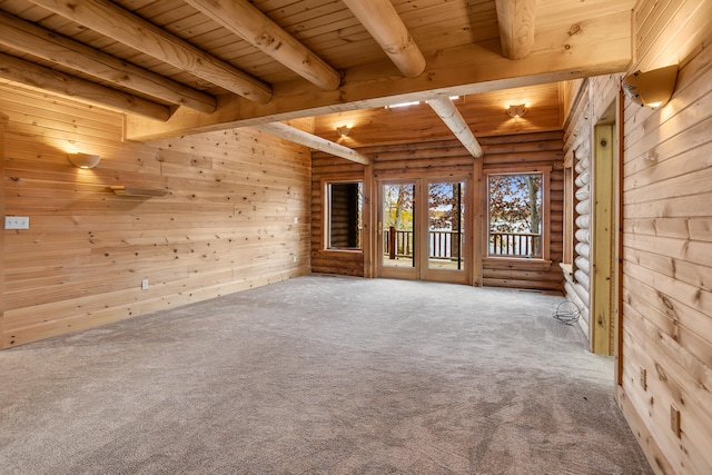 carpeted empty room with wood walls, wood ceiling, and beam ceiling