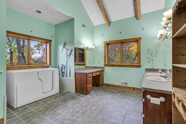 bathroom with a tub, beamed ceiling, vanity, and tile patterned floors