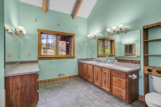 bathroom with lofted ceiling with beams, tile patterned flooring, a healthy amount of sunlight, and toilet