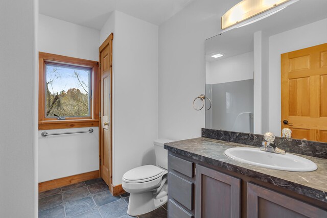 bathroom with toilet, vanity, and tile patterned flooring