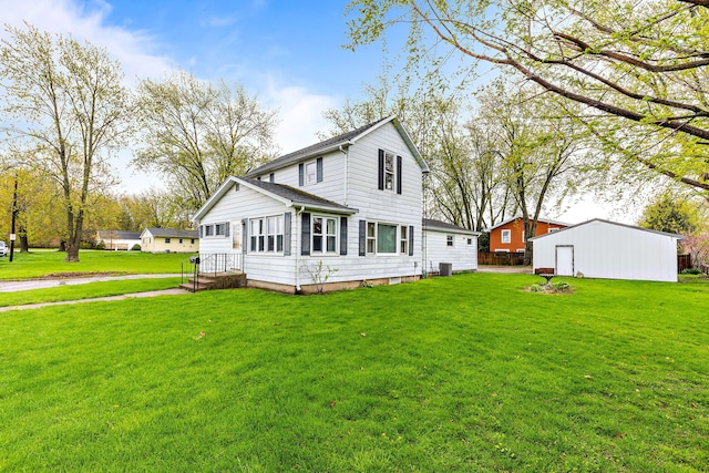 rear view of property with an outbuilding and a yard