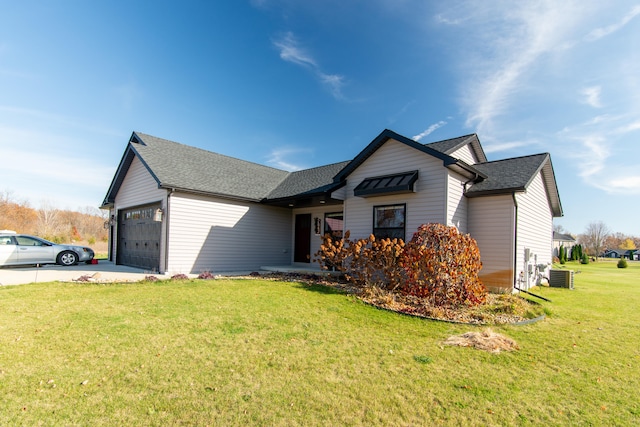 view of front of property featuring a garage, cooling unit, and a front lawn