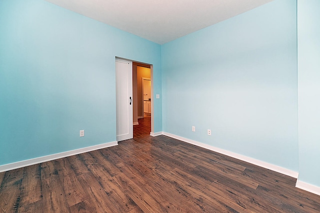 unfurnished room with dark hardwood / wood-style flooring