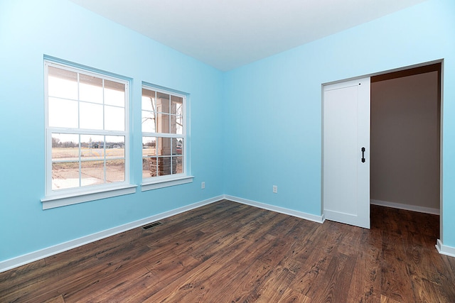 unfurnished room featuring dark wood-type flooring